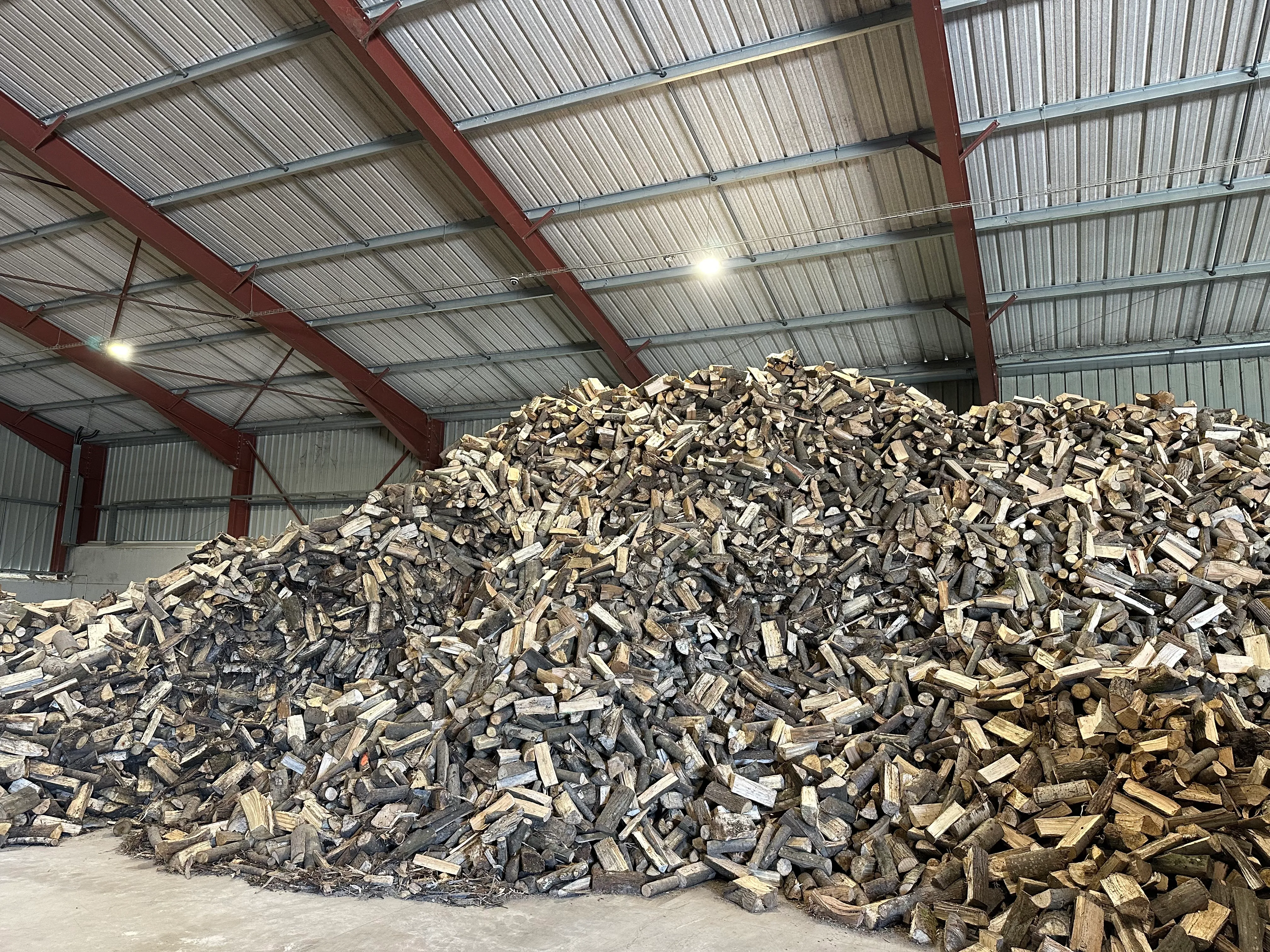 Tas de bûches de bois sec stockées sous hangar — Chevru Bois